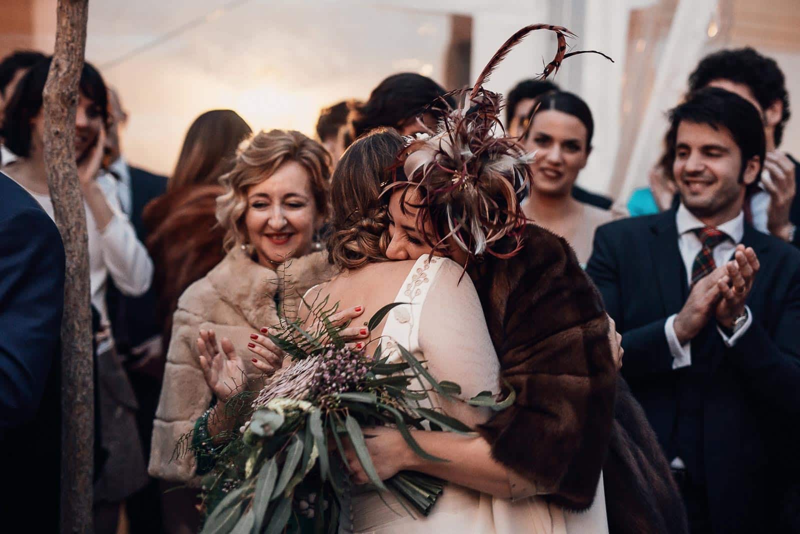 abrazo novia invitados tocado ramo flores abrigos