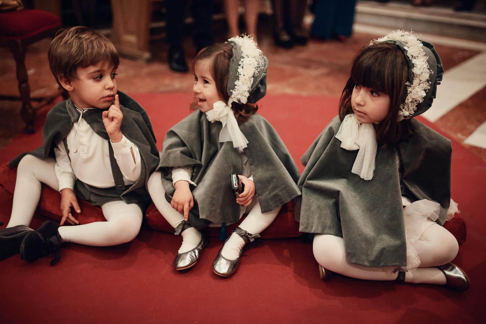 niños capas terciopelo flores suelo iglesia